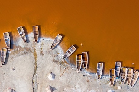 Aerial view of the small boats for salt collecting at pink Lake Retba or Lac Rose in Senegal.